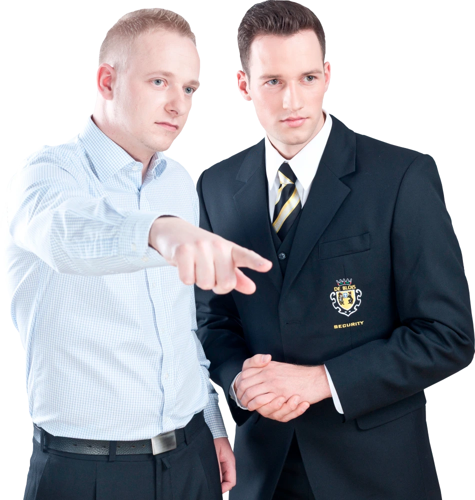 Zwei Männer, einer zeigt in eine Richtung, der andere trägt eine Sicherheitsuniform.